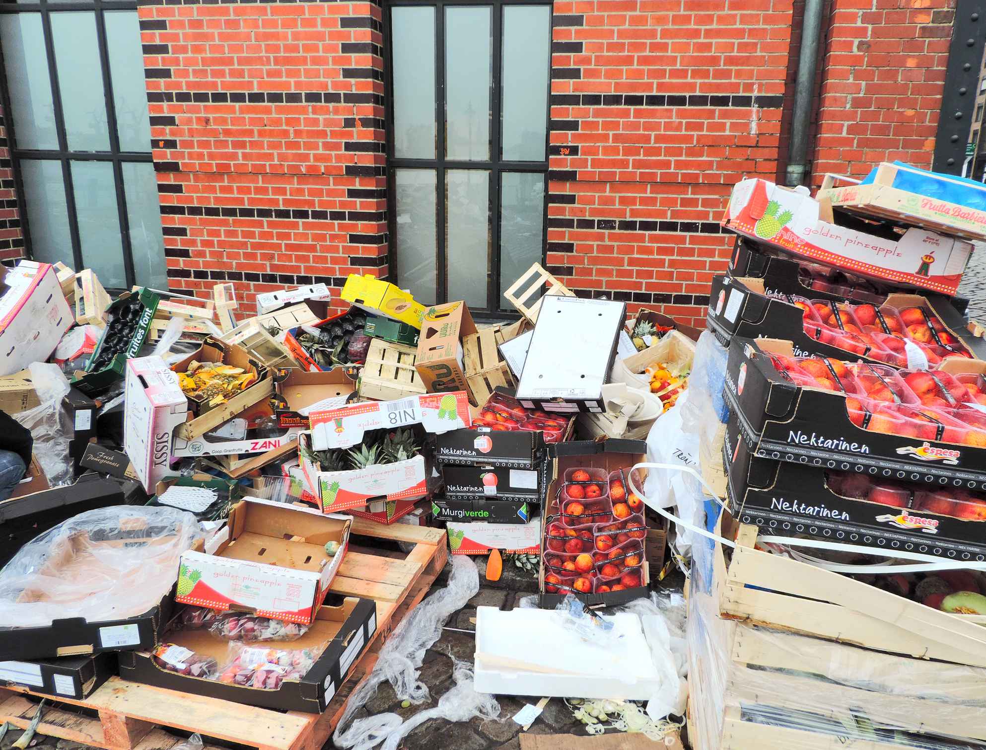 Cajas de comida tiradas y almacenadas en un callejón