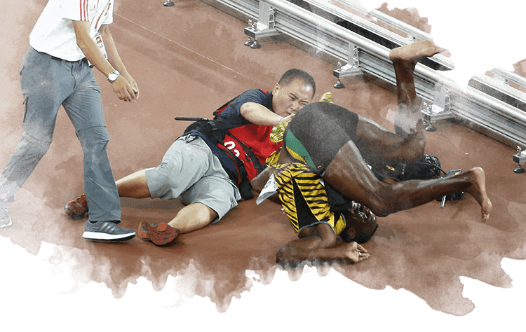 Un cámara de televisión tras chocar contra Usain Bolt después de la final masculina de 200m en los Mundiales de Atletismo de China 2015