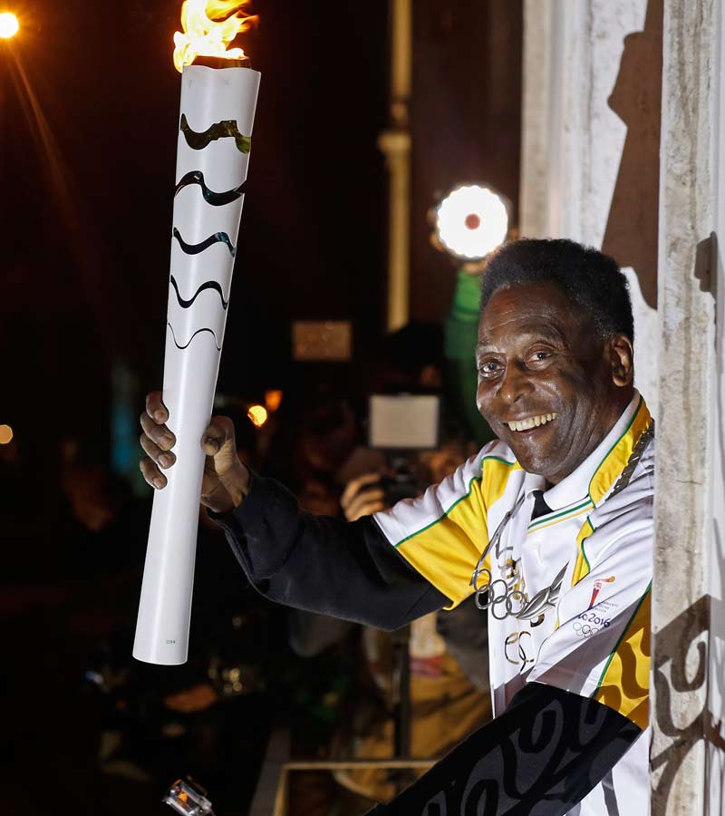  El exjugador de fútbol, Pelé, portando la llama olímpica